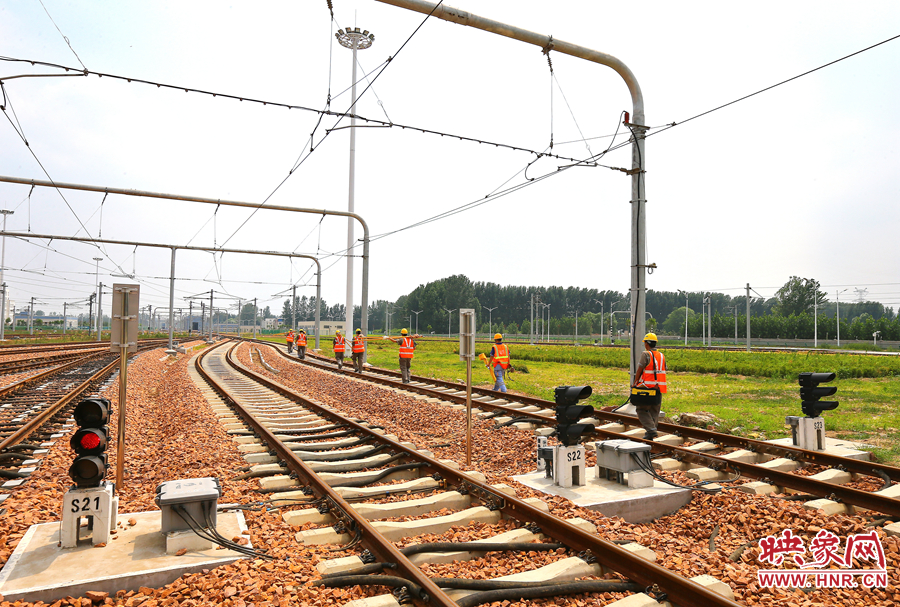 在太陽的直射下，檢修工人扛著沉重的設(shè)備向施工地點出發(fā)