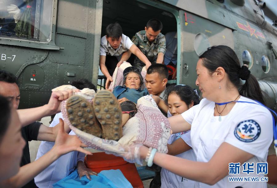 8月5日，醫(yī)護人員將一名通過直升機從震中轉(zhuǎn)運出來的傷員運下飛機。