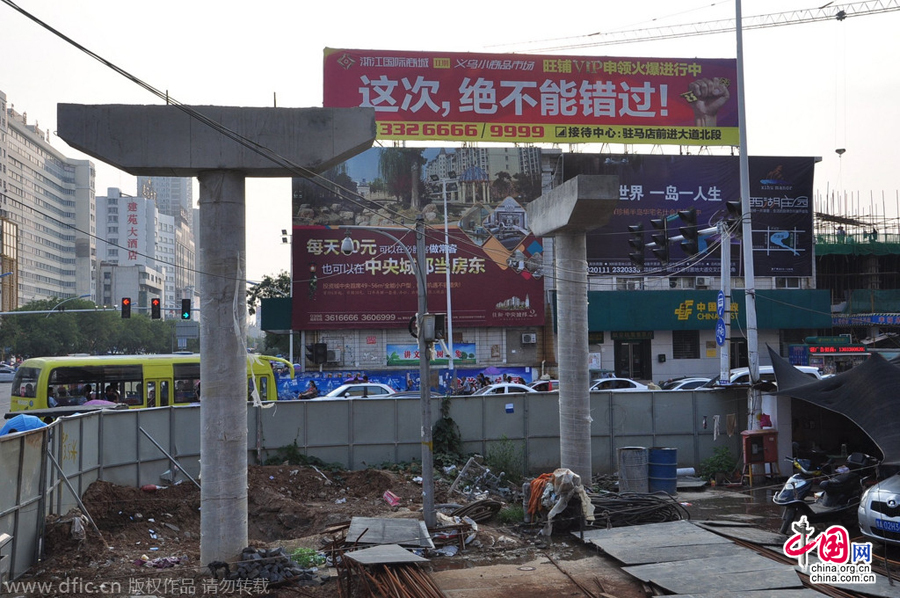 過街天橋一側的橋樁早已打好,可是對面的郵政銀行網(wǎng)點依舊在照常營業(yè)。