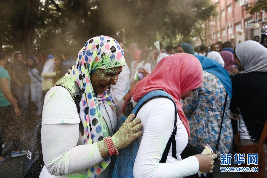 10月16日，在埃及首都開羅，兩名女青年在“彩色跑”活動(dòng)中躲避人們拋撒的彩色粉末。