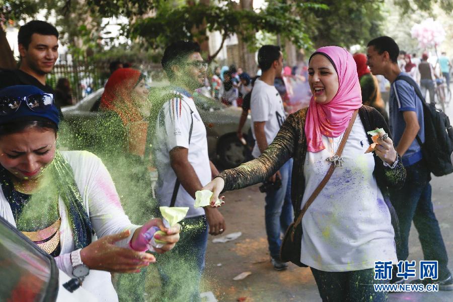 10月16日，在埃及首都開羅，一名女青年在“彩色跑”活動(dòng)中拋撒彩色粉末。