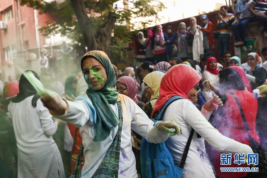 10月16日，在埃及首都開羅，一名女青年在“彩色跑”活動(dòng)中拋撒彩色粉末。