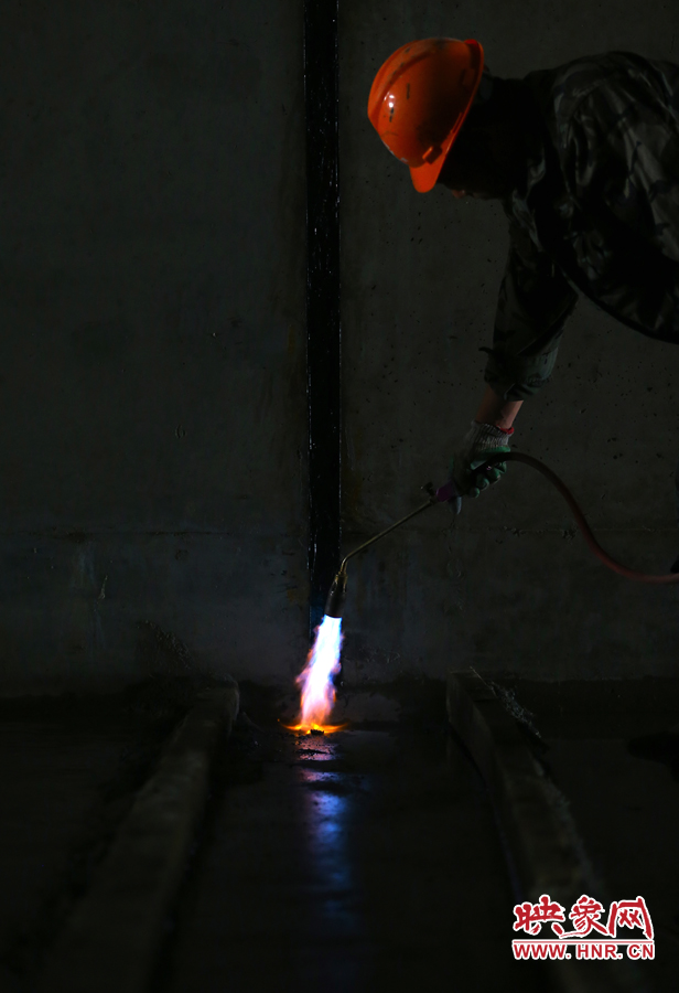 工人師傅用噴槍烘干地面，便于做防水處理