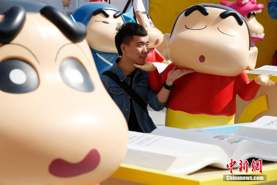 4月22日，游客與蠟筆小新合影?！跋灩P小新25周年紀(jì)念特展”日前在北京開展，吸引了不少市民游客。