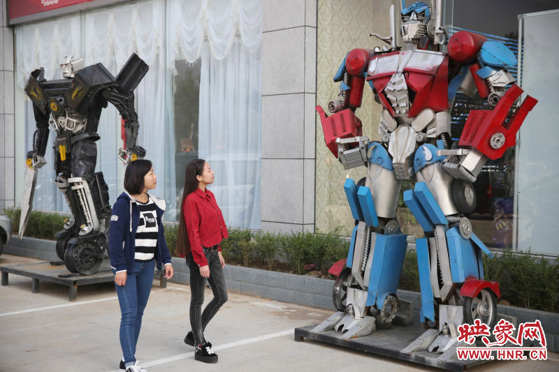 10月14日，市民在參觀河南省平頂山市寶豐縣一家企業(yè)門前的“變形金剛”。