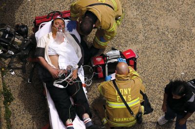 2日，救援人員在美國紐約地鐵事故車輛內(nèi)緊急疏散一名受傷乘客。圖/CFP