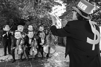 4日在布魯塞爾，非政府組織『樂施會』成員戴著七國首腦面具演奏名曲《錢錢》，批評七國政策導(dǎo)致全球貧富差