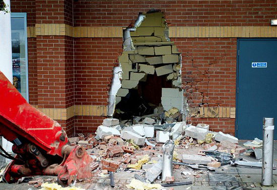 劫匪利用挖掘機(jī)的機(jī)械臂移走ATM機(jī)，留下滿地狼藉