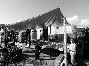 黎巴嫩一敘利亞難民營(yíng)，難民支起攤鋪賣(mài)衣服掙錢(qián)。