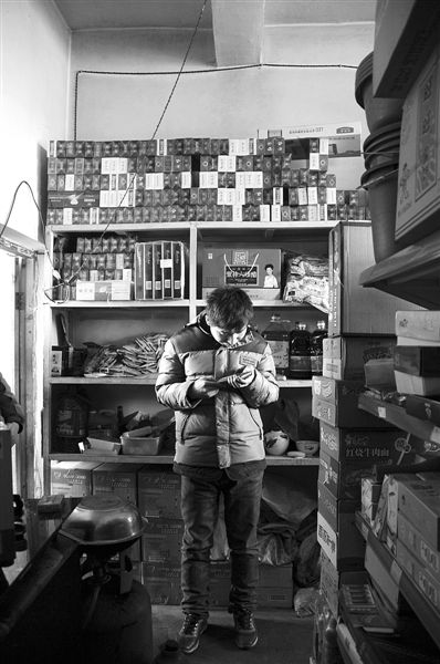 1月21日，周瑋在自家的超市里玩計算器。