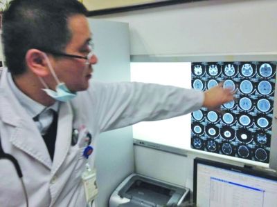 醫(yī)生在查看男孩的腦部CT片。薛馬義 攝