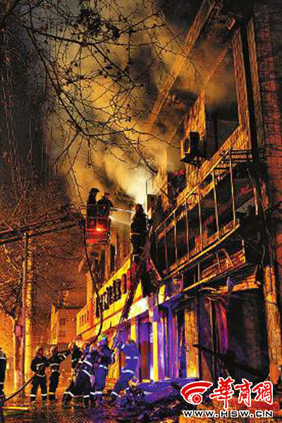 昨日22時10分，西安市豐慶路南小巷南口，消防官兵架梯子登上二樓施救 本組圖片由本報記者 閆文青 攝