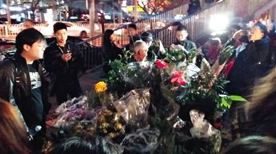 昨晚7時(shí)許，三里屯太古里西邊附近一過(guò)街天橋旁邊，聞?dòng)嵍恋木W(wǎng)友圍住了賣花老人，爭(zhēng)相買花。 網(wǎng)友“行者橙子”供圖