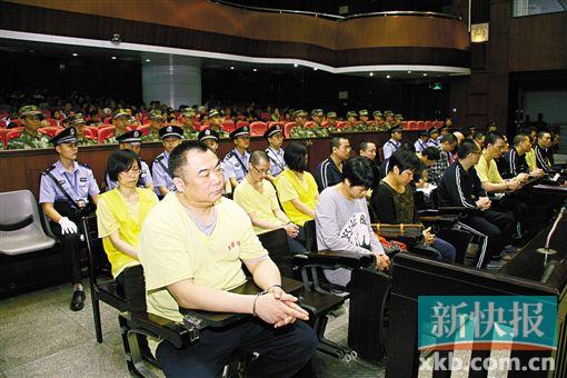 ■蔣洪偉(左一)等二十幾名被告被指控犯集資詐騙罪,昨日集體過(guò)堂?！　?鄭朝暉/攝