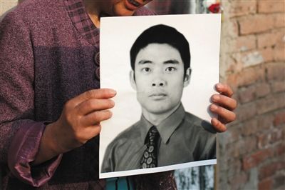 5月19日，朝陽北路，母親捧著張東文的遺像。新京報記者 侯少卿 攝