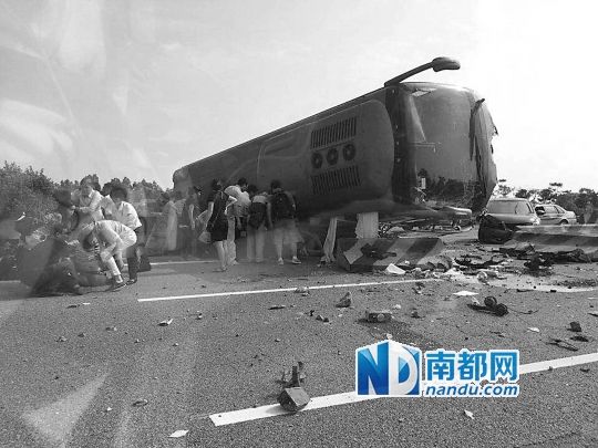 現(xiàn)場大客車側(cè)翻，玻璃碎落一地，車身卡在路邊水泥護欄上。 目擊者供圖