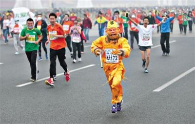 長(zhǎng)安街，一名打扮成孫悟空的參賽者在北馬隊(duì)伍里飛奔。 本版攝影/新京報(bào)記者 吳江 李飛 王嘉寧 吳江