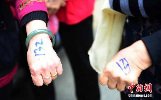 圖為10月28日，在江西九江市一家羊絨皮草服裝服飾博覽會(huì)現(xiàn)場(chǎng)，老人們正在頂著寒風(fēng)排隊(duì)等待領(lǐng)取10元代金劵。