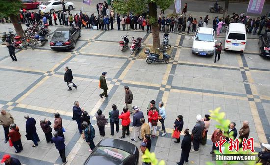 圖為10月28日，在江西九江市一家羊絨皮草服裝服飾博覽會(huì)現(xiàn)場(chǎng)，老人們正在頂著寒風(fēng)排隊(duì)等待領(lǐng)取10元代金劵。