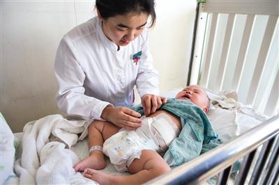 昨日，北京兒童醫(yī)院，護(hù)士為即將出院的被扎鋼針女嬰檢查傷口恢復(fù)情況。記者 高瑋 攝