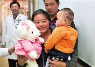 昨日上午，被扎針女嬰的母親抱著孩子和醫(yī)護(hù)人員送的玩偶準(zhǔn)備出院，院方稱孩子術(shù)后恢復(fù)良好。記者 高瑋 攝