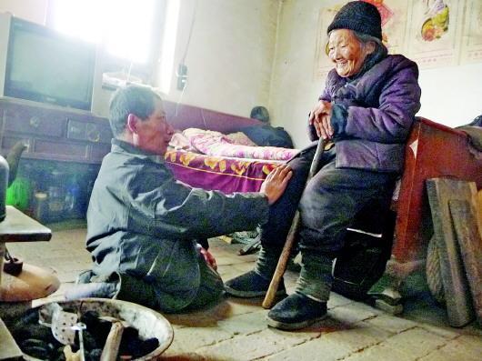 52歲的劉蘭山每天靠爬行照顧90歲的老母親。孫國祥 攝