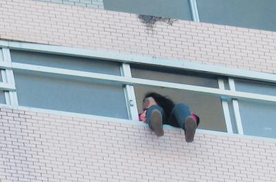 28樓的窗臺(tái)上坐著一名女子，其兩條腿耷拉在室外，不停地?cái)[動(dòng)。