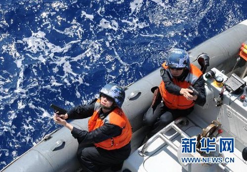 　3月28日，十余名臨檢拿捕隊員乘小艇駛至模擬可疑商船下方水面。