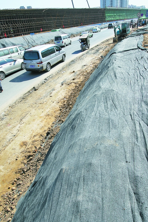 豐樂路與北三環(huán)交叉口，修路的土被歸置得整整齊齊，并用黑網(wǎng)覆蓋，既保暢通又避免了揚(yáng)塵。