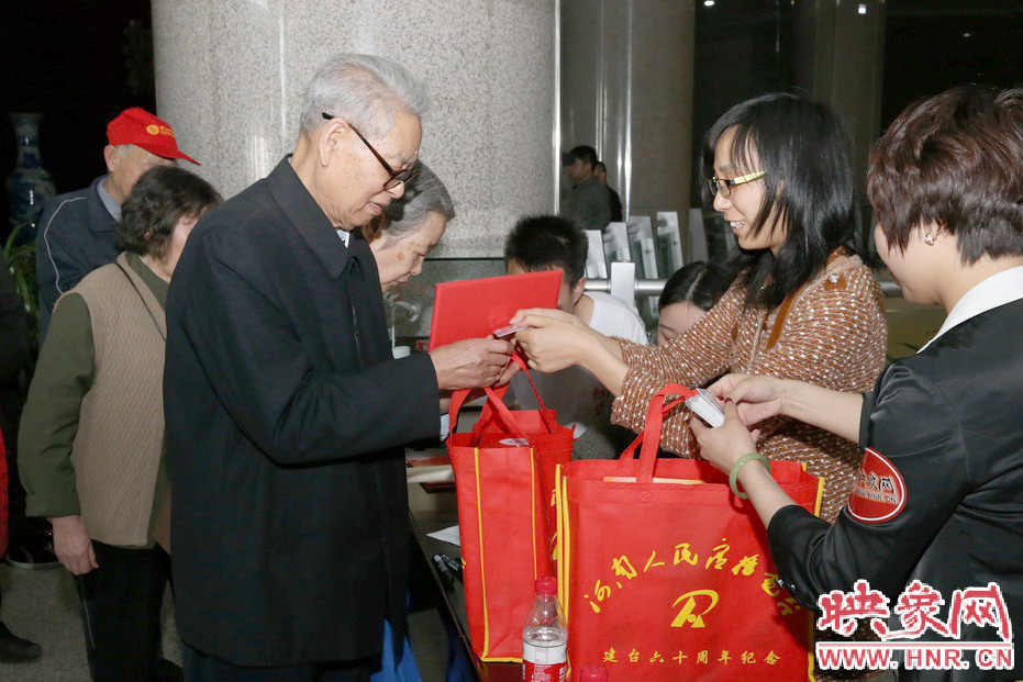 映象網(wǎng)工作人員為勞模發(fā)放紀念品