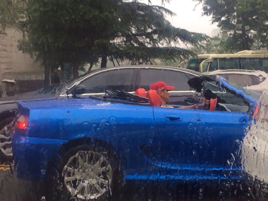 男子雨中開(kāi)敞篷車 網(wǎng)友:土豪的世界咱不懂