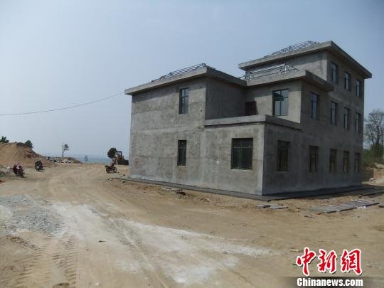 鴨河水庫庫區(qū)邊的新建別墅，一面墻上寫著“拆”，另一邊在加緊施工。吳揚(yáng)　攝